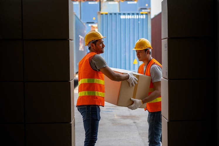 Workers are helping to load goods into containers.
