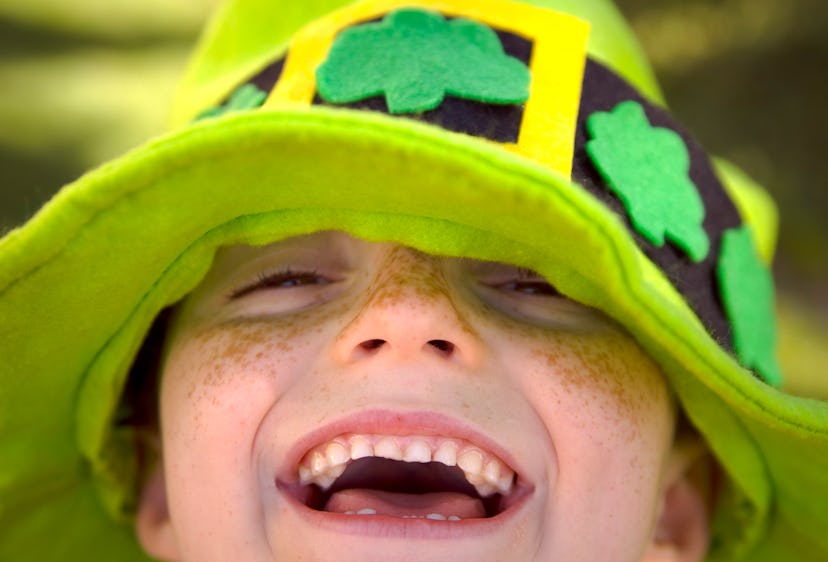happy kid in green leprechaun hat in st patrick's day puns article