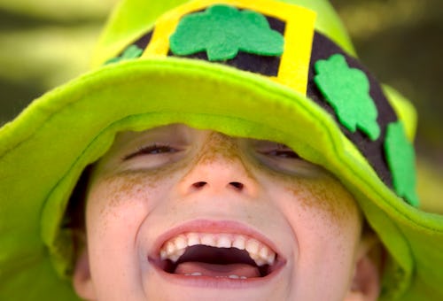 happy kid in green leprechaun hat in st patrick's day puns article