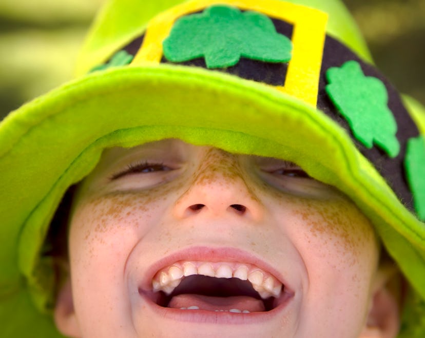 happy kid in green leprechaun hat in st patrick's day puns article