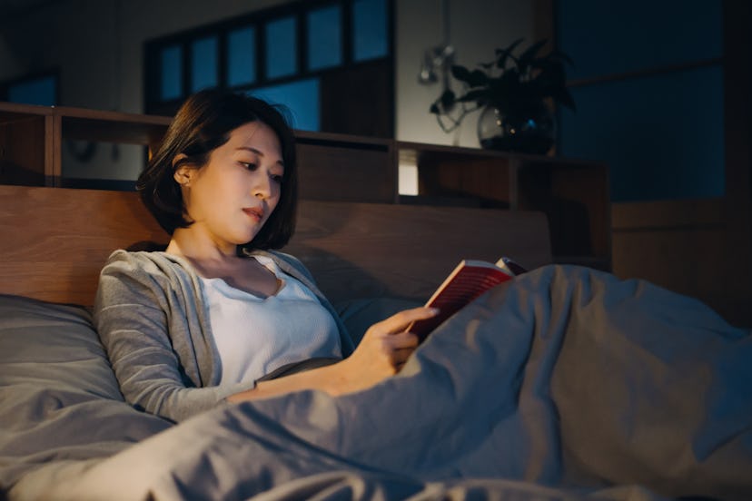 A woman reads in bed.