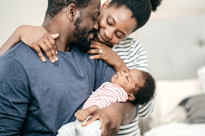 Authentic moment of parenthood, a cute couple looking at their baby in an article about postpartum i...