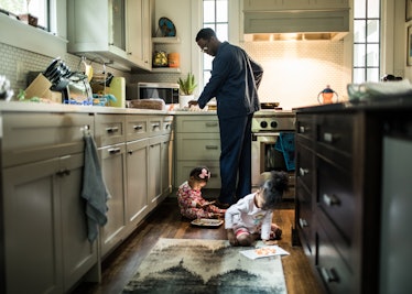Father cooking breakfast for daughters in kitchen