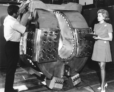 A project engineer makes measurements on the coil form for the Baseball II superconducting magnet wh...