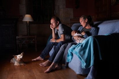 a sleepy couple with a newborn. Watching TV at night may contribute to postpartum insomnia