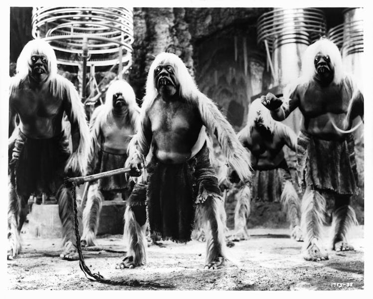 Morlocks, one with whip in hand, prepare to attack the Eloi who have been led underground in a scene...