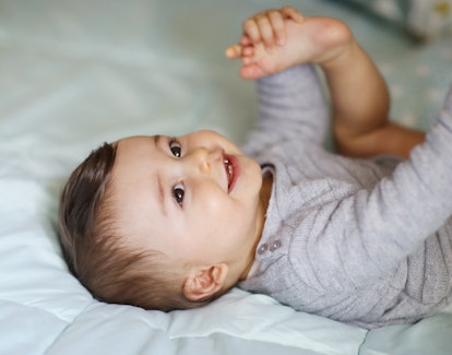 cute picture of baby playing in bed in article about strong aries baby boy names