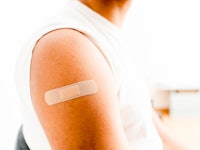 adhesive bandage, on the arm of a black man after giving him the covid19 vaccine.