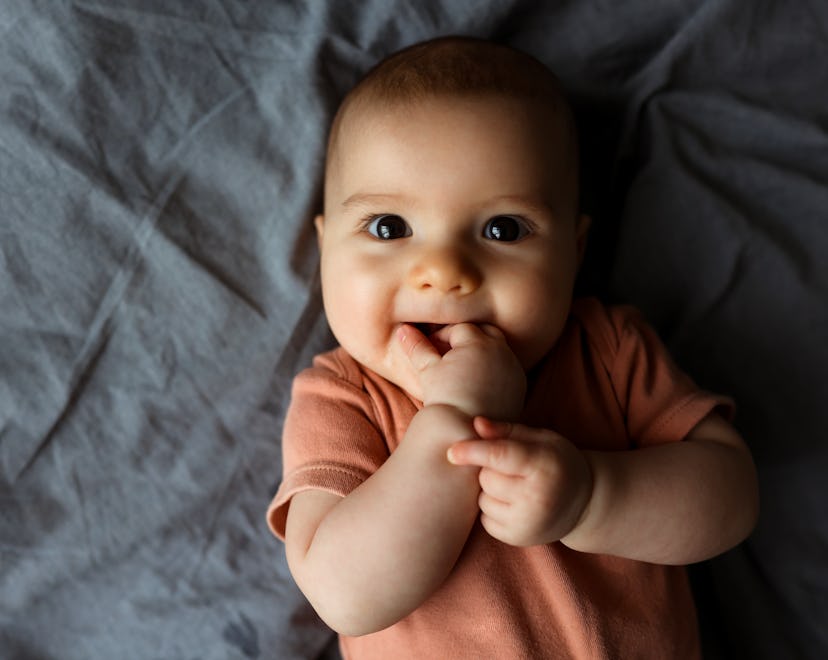Small beautiful child lies on the bed in article about aries girl names