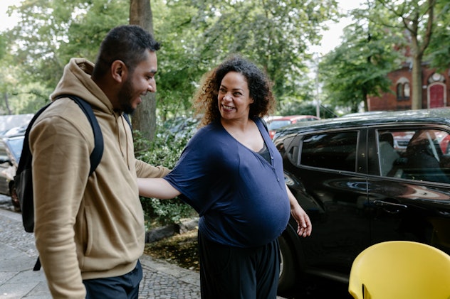 Pregnant greeting friend on a city street, hopefully he's not saying one of these things not to say ...