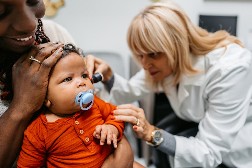 To diagnose baby's ear infection, a pediatrician check's the infant's ears.