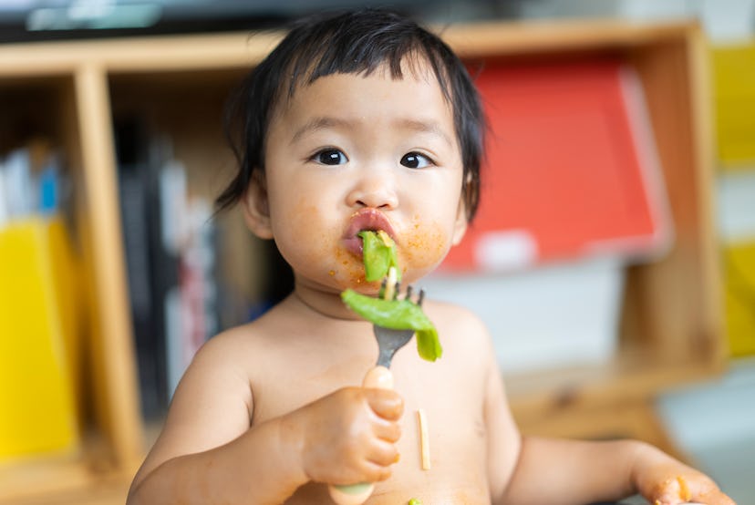 cute baby eating food, in an article about when can babies eat baby food.