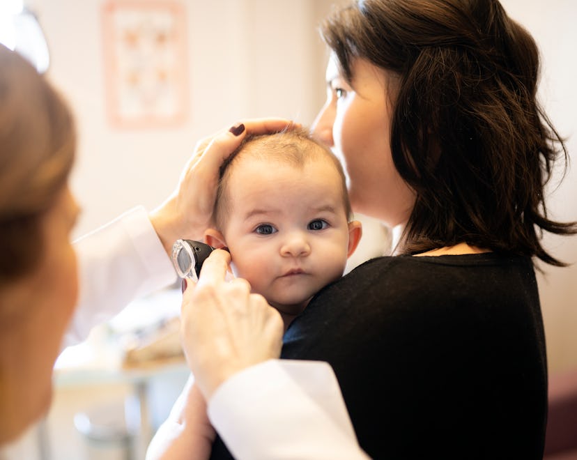 To diagnose baby's ear infection, a pediatrician check's the infant's ears.