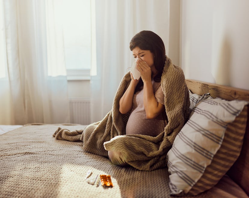 pregnant person blows her nose in an article about is it OK to take Benadryl during pregnancy?