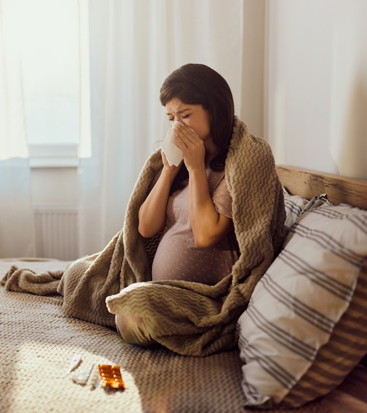 pregnant person blows her nose in an article about is it OK to take Benadryl during pregnancy?