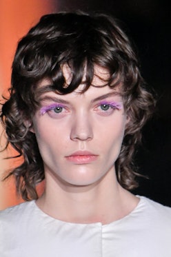 a model wearing colorful lashes at prada's fall/winter 2023 fashion show