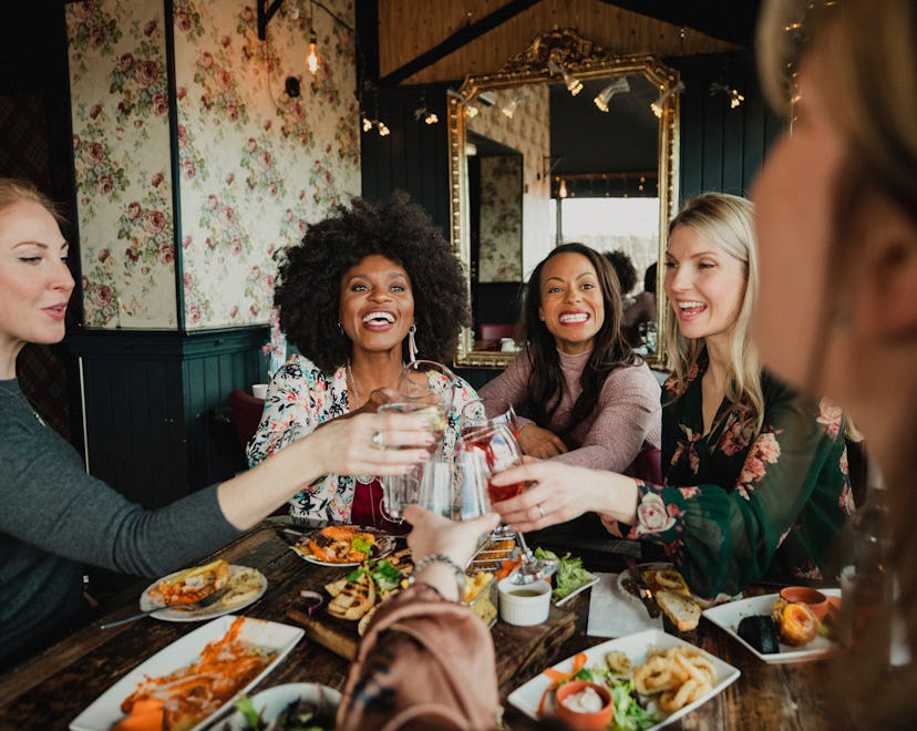 An over the shoulder shot of a group of beautiful mid-adult women enjoying a celebratory toast toget...