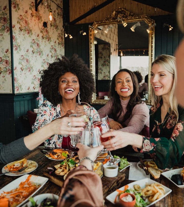 An over the shoulder shot of a group of beautiful mid-adult women enjoying a celebratory toast toget...