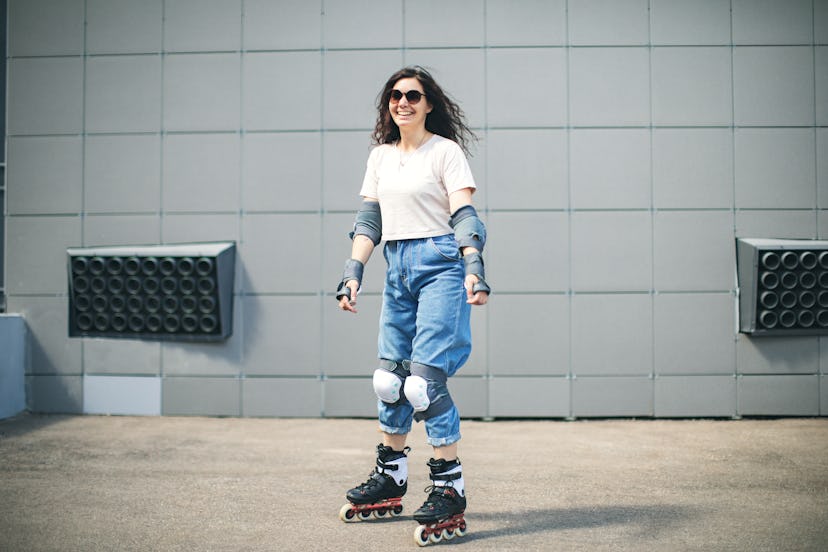 Young adult woman roller skating outdoors and doing tricks