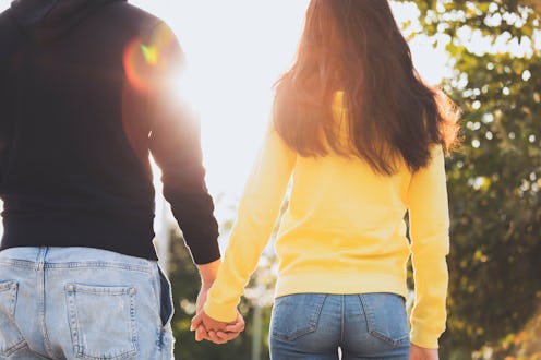 Rearview of an unrecognizable couple holding hands. Welcoming the sunrise.