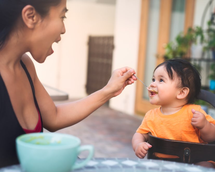 A pretty mom feeds her happy 7 month old baby solid food. when can babies eat meat?