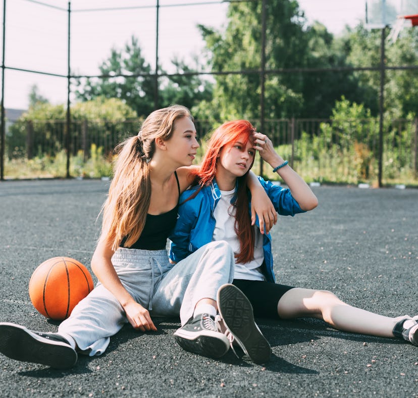 two friends sit on basketball court with a basketball, as they consider the May 2023 flower lunar ec...