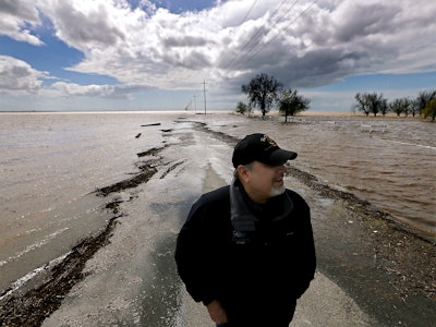 LEMOORE, CALIF. - MAR. 21, 2023. Agribusiness consultant Mark Grewel stands on a farm road that was ...
