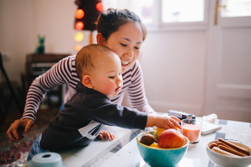 Brightly lit image of a young Thai mom with her little baby boy. when can babies eat meat?