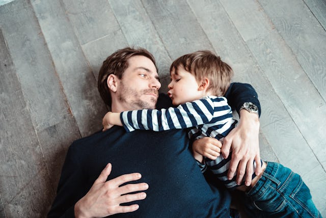 A father and a son cuddle together. A new study has found that sons often copy their father's approa...