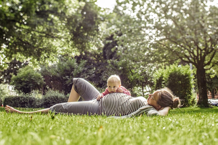 Can you take Claritin while pregnant? This pregnant mom lies in the grass in the sun while her older...