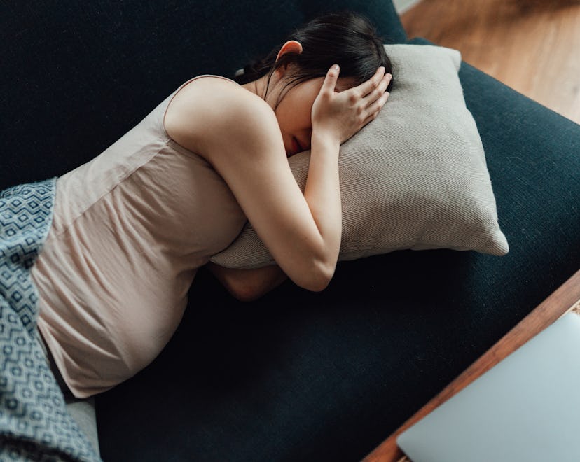 Can you take Mucinex while pregnant? A pregnant woman lies on the couch with her hand on her head, f...