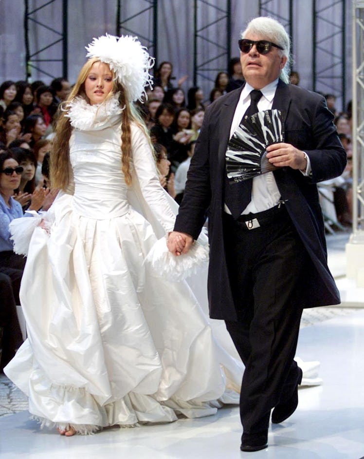 German designer Karl Lagerfeld (R) of Chanel leads Japanese model Devon Aoki 