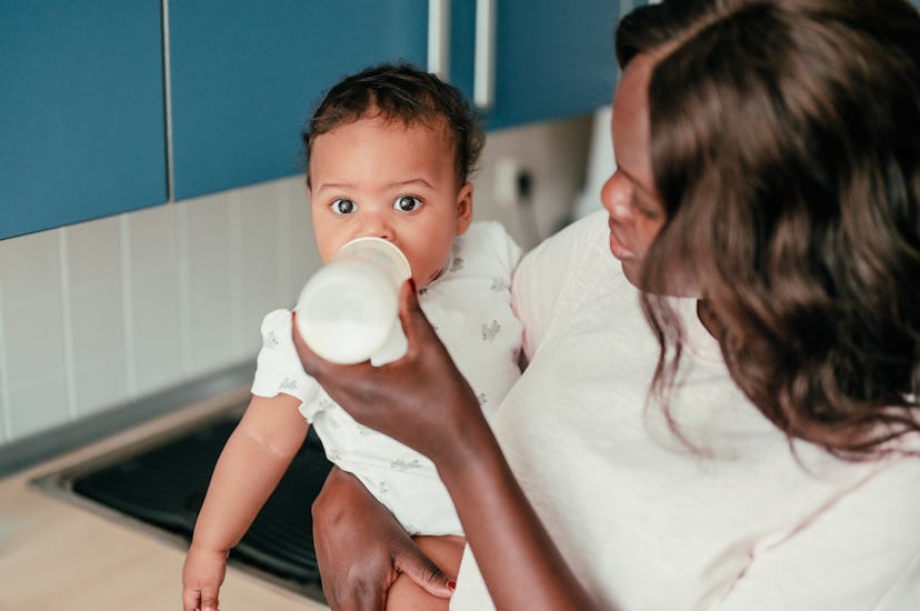 mother bottle feeding baby in article about how to properly store breast milk in the fridge or freez...