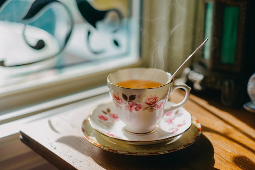 steaming cup of green tea in floral tea cup and saucer in article about drinking green tea during pr...