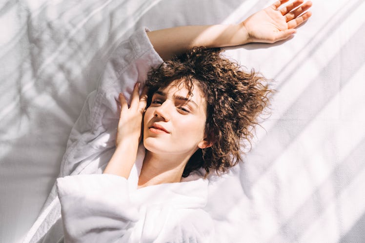 young woman poses as she considers what her zodiac sign needs to have the best sleep ever
