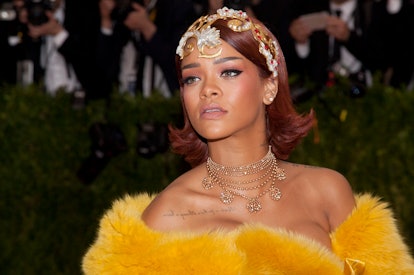 Rihanna with red hair and a delicate headpiece at the 2015 Met Gala.