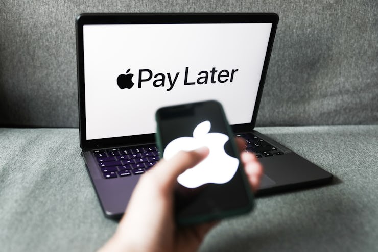 Apple Pay Later logo displayed on a laptop screen and Apple logo displayed on a phone screen are see...
