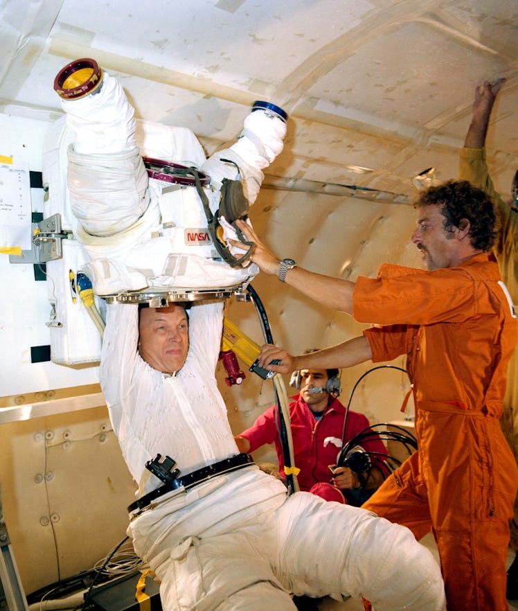 (November 1982) --- Astronaut F. Story Musgrave, STS-6 mission specialist, is assisted in a suit don...