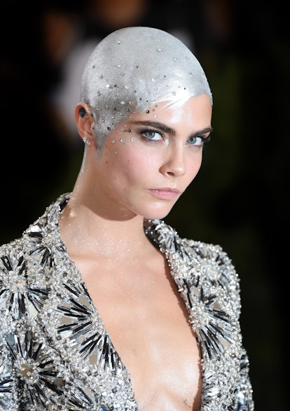 Cara Delevingne with her shaved hair covered in silver paint at the Met Gala in 2017.