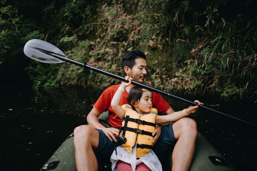 Father and young daughter in kayak, in a story about how to choose the best life jacket for kids.