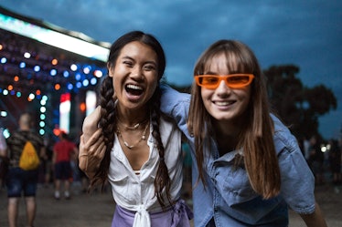two friends pose for a photo at a festival as they consider why their signs will be the luckiest in ...