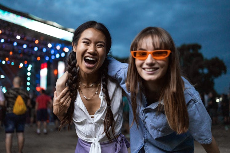 two friends pose for a photo at a festival as they consider why their signs will be the luckiest in ...