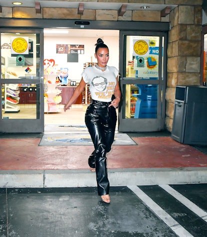 Kim Kardashian wears a graphic white T-shirt and black leather pants. 