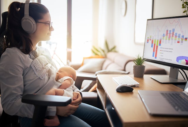Multi-tasking woman working at home while breastfeeding her baby boy. A CEO recently went viral for ...