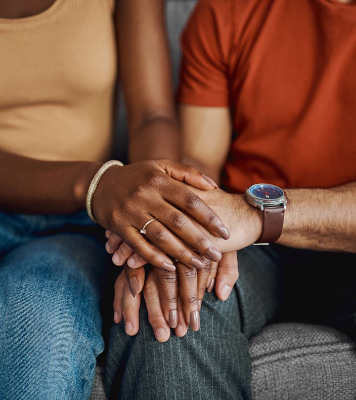 a couple holds hands, in a list of signs your marriage can survive infidelity