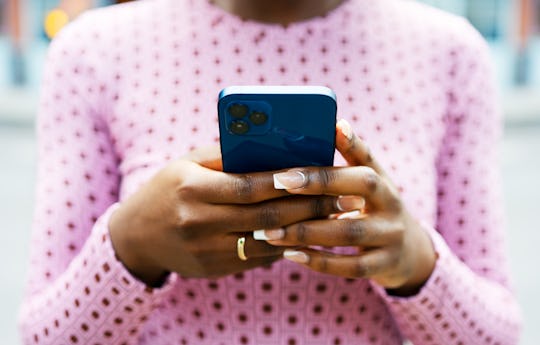 Woman's hands texting on smart phone, in a story about what to text friend who is freezing their egg...