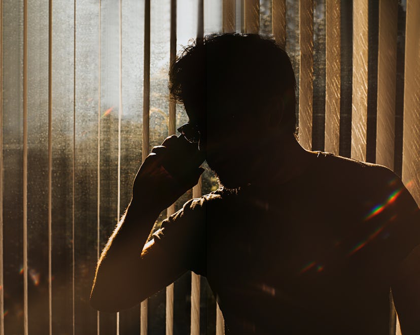 Silhouette of an unknown man on a phone against window blinds in article about rage disorder