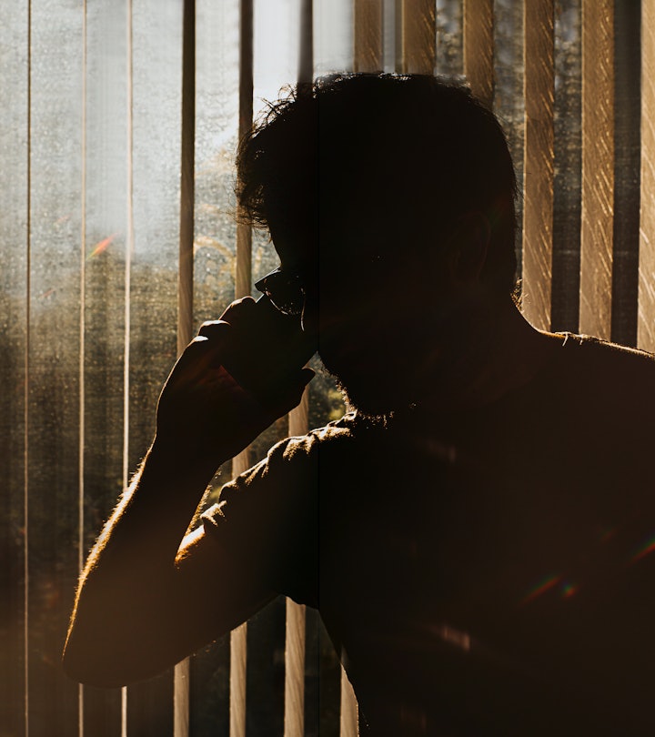 Silhouette of an unknown man on a phone against window blinds in article about rage disorder