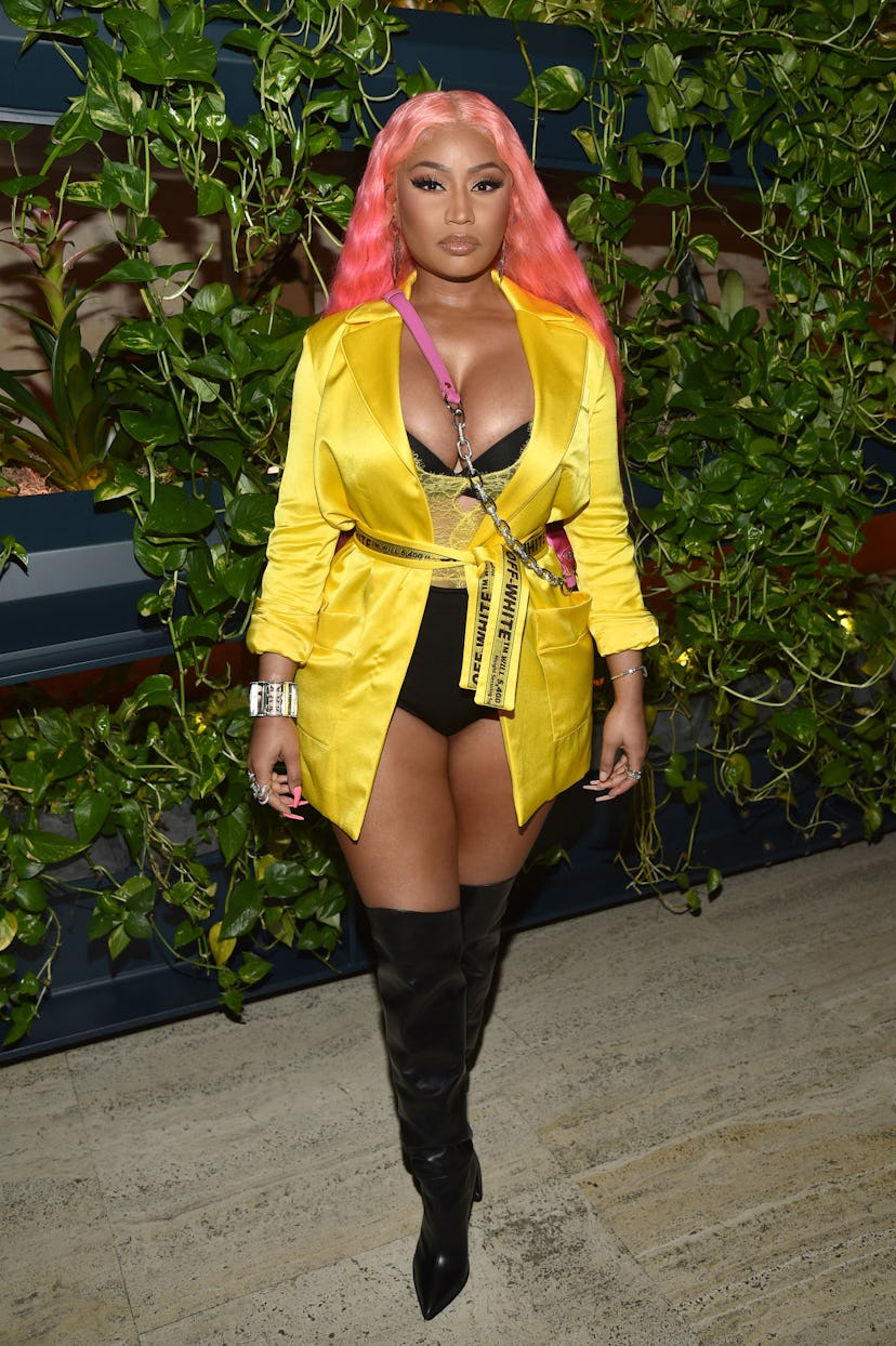 Nicki Minaj wears black undies, a yellow blazer, and over-the-knee boots. 