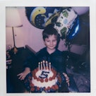 Child with  birthday cake.  Polaroid photo.